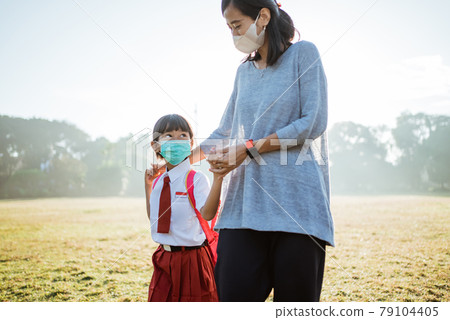mother and her daughter walking together and wear face mask mother and her daughter walking together and wear face mask 79104405