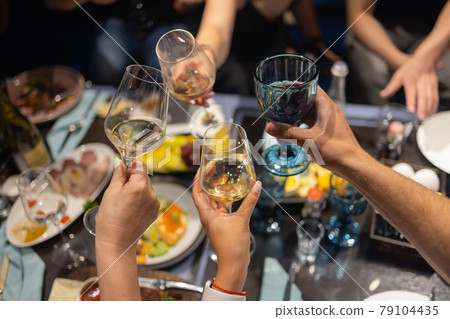 Clinking glasses with alcohol and toasting, party. 79104435