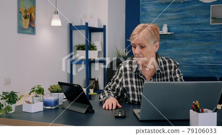 Mature woman using tablet and laptop in same time analysing financial graphs Mature woman using tablet and laptop in same time analysing financial graphs 79106033