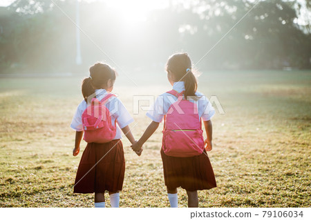 two girl friend primary school student walking together 79106034
