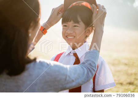 mother fixing her daughter primary school student uniform mother fixing her daughter primary school student uniform 79106036