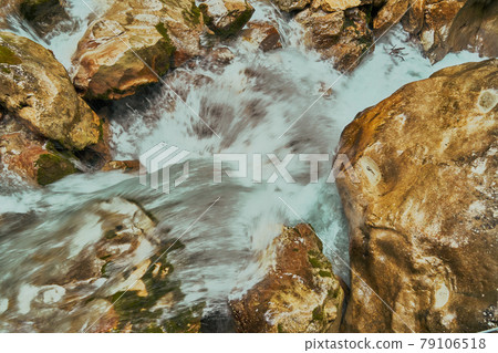 Close-up view of the bubbling foaming water in a mountain stream in a gorge 79106518