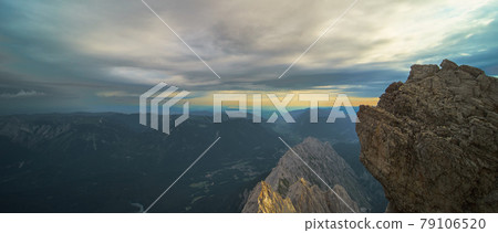 View over the Austrian and Swiss Alps from the Zugspitze, with a dramatic sky over the rugged mountains. 79106520