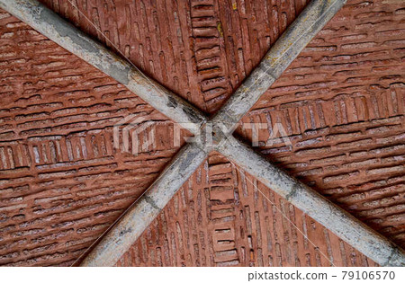 Abstract impression, pattern, texture by a historical brick ceiling in a vault with a crossed grey supporting structure 79106570