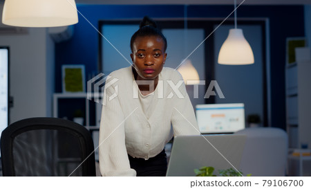 Focused tired business woman looking at camera after reading mails on laptop Focused tired business woman looking at camera after reading mails on laptop 79106700
