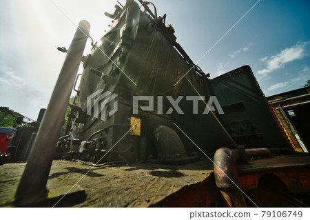 Wide-angle shot against the sun from a historic black locomotive made of iron Wide-angle shot against the sun from a historic black locomotive made of iron 79106749