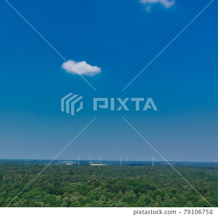 Horizontal aerial view to the horizon with blue sky, much copy space, a small cloud and windmills 79106758