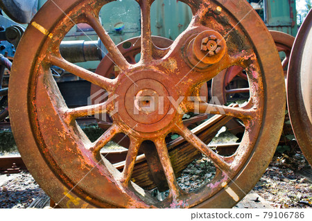 Detail of an old rusty weathered iron red wheel of a historic locomotive 79106786