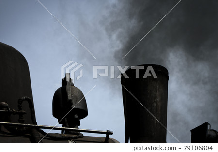 Detailed view of a black historic steam locomotive blowing black rusty smoke out of a chimney, transport, black and white 79106804