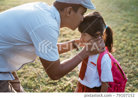 father kiss her daughter forehead when taking her to school in the morning 79107152