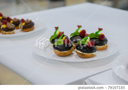 Fresh shortcrust tart cakes with chocolate and fruits on white plate for sale 79107185
