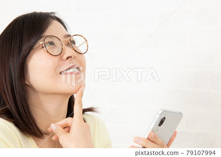 年輕的眼鏡女孩和智能手機 年輕的眼鏡女孩和智能手機 79107994