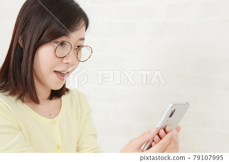 年輕的眼鏡女孩和智能手機 年輕的眼鏡女孩和智能手機 79107995