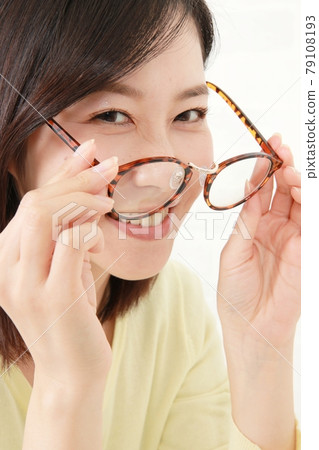A young woman who removes glasses from a tortoiseshell Boston frame A young woman who removes glasses from a tortoiseshell Boston frame 79108193