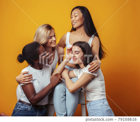 diverse multi nation girls group, teenage friends company cheerful having fun, happy smiling, cute posing on yellow background, lifestyle people concept, african-american, asian and caucasian diverse multi nation girls group, teenage friends company cheerful having fun, happy smiling, cute posing on yellow background, lifestyle people concept, african-american, asian and caucasian 79108616