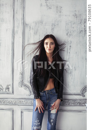young brunette woman in leather jacket at vintage wall young brunette woman in leather jacket at vintage wall 79108635