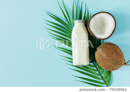 Coconut vegan milk top view on blue background. Coconut vegan milk top view on blue background. 79108962