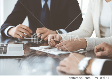 Business people discussing contract working together at meeting in modern office. Unknown businessman and woman with colleagues or lawyers at negotiation Business people discussing contract working together at meeting in modern office. Unknown businessman and woman with colleagues or lawyers at negotiation 79109187