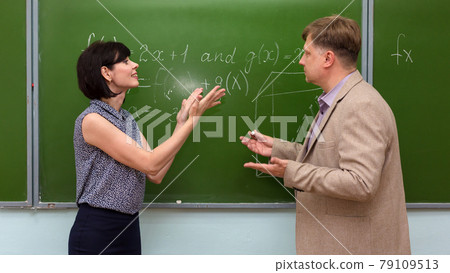 A student explains to the teacher the solution of the problem at the blackboard A student explains to the teacher the solution of the problem at the blackboard 79109513
