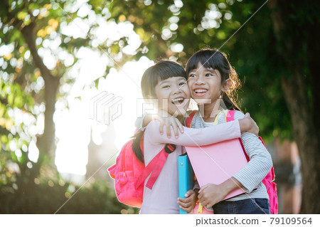 kid student laughing while sitting in the park 79109564