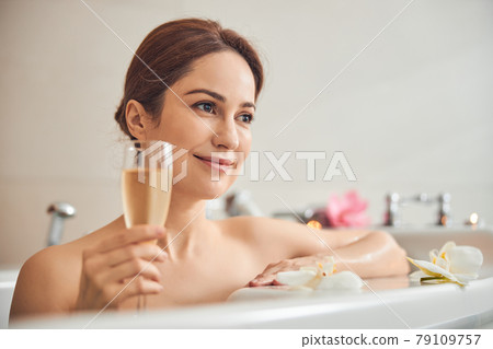 Cute Caucasian woman resting with a drink at home 79109757