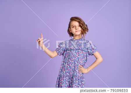 Look There. Excited Caucasian Kid Girl Pointing Thumb At Free Space For Text Posing On Purple Studio Background. Panorama Look There. Excited Caucasian Kid Girl Pointing Thumb At Free Space For Text Posing On Purple Studio Background. Panorama 79109833