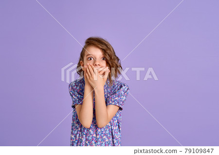 Young girl wearing flower print dress over purple isolated background shocked covering mouth with hand. 79109847