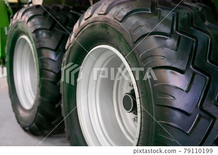 Close up view of two heavy tractor tires and wheels at farming exhibition 79110199
