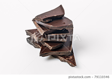 A stack of dark chocolate on a white background. Pieces of bitter cracked chocolate. Food photography. Close-up. Copy space A stack of dark chocolate on a white background. Pieces of bitter cracked chocolate. Food photography. Close-up. Copy space 79110346