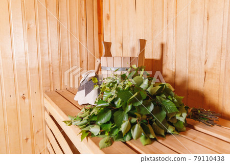 Traditional old Russian bathhouse SPA Concept. Interior details Finnish sauna steam room with traditional sauna accessories basin birch broom scoop felt. Relax country village bath concept. 79110438