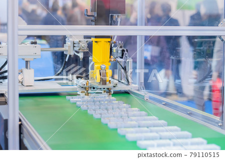 Pick and place robotic arm manipulator moving plastic detail on conveyor belt Pick and place robotic arm manipulator moving plastic detail on conveyor belt 79110515