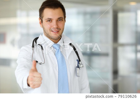 Male doctor standing in the modern clinic. Perfect medical service in the hospital. Medicine and healthcare concept Male doctor standing in the modern clinic. Perfect medical service in the hospital. Medicine and healthcare concept 79110626