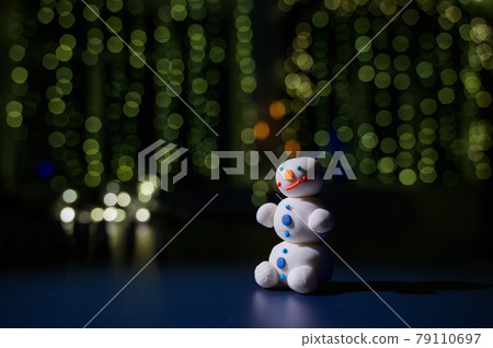 Cute snowman and little Christmas trees made of marshmallows on the background of Christmas lights. White mug of hot chocolate and sweets. Cute snowman and little Christmas trees made of marshmallows on the background of Christmas lights. White mug of hot chocolate and sweets. 79110697