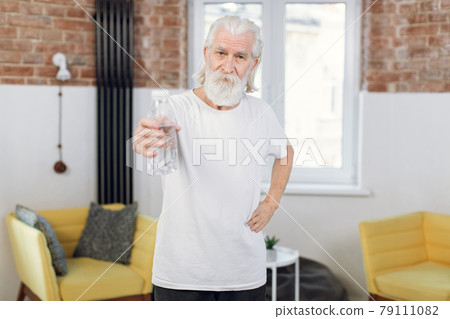 Elderly man holding bottle of water after workout Elderly man holding bottle of water after workout 79111082