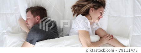Young man and woman lying under covers top view Young man and woman lying under covers top view 79111475