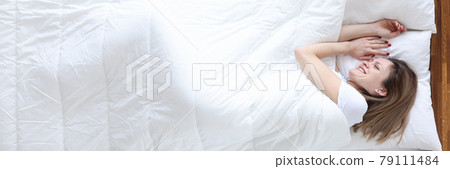 Woman lying in bed and smiling top view Woman lying in bed and smiling top view 79111484