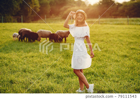 Cute girl in a field with a goats Cute girl in a field with a goats 79111543