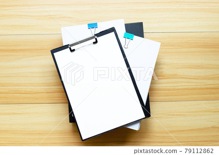 Paper with office folder on wooden table background. Top view 79112862