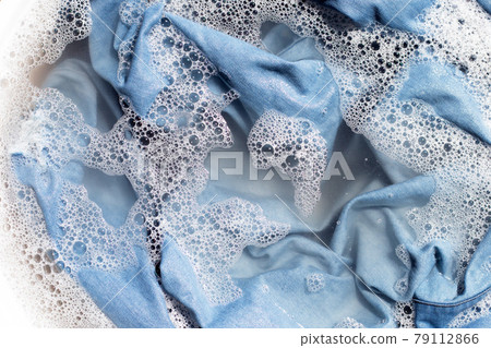 Jean shirt soak in powder detergent water dissolution, washing cloth. Laundry concept Jean shirt soak in powder detergent water dissolution, washing cloth. Laundry concept 79112866