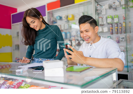 a business man using a smartphone and a business woman using a calculator a business man using a smartphone and a business woman using a calculator 79113892