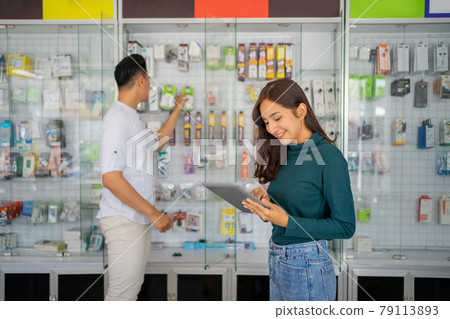beautiful business girl using a digital tablet on the background a smartphone shop beautiful business girl using a digital tablet on the background a smartphone shop 79113893