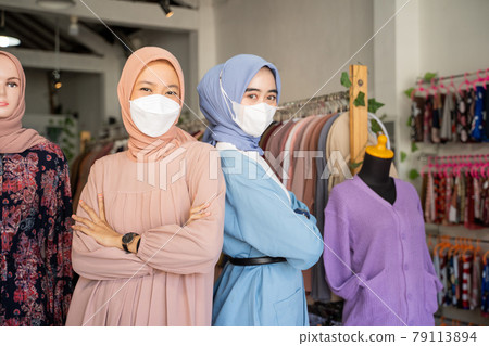 two veiled business women wearing masks with their arms crossed as they stand back to back two veiled business women wearing masks with their arms crossed as they stand back to back 79113894