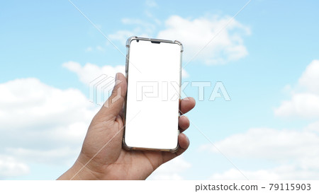 Man's hand holding smartphone with sky background Man's hand holding smartphone with sky background 79115903