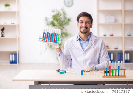 Young male chemist working at the lab 79117357