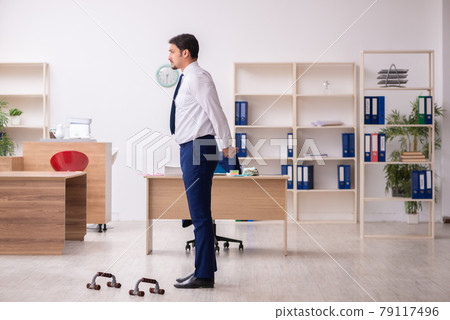 Young male employee doing sport exercises during break Young male employee doing sport exercises during break 79117496