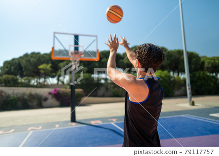 Male sportsman playing basketball throwing the ball at playgroun 79117757