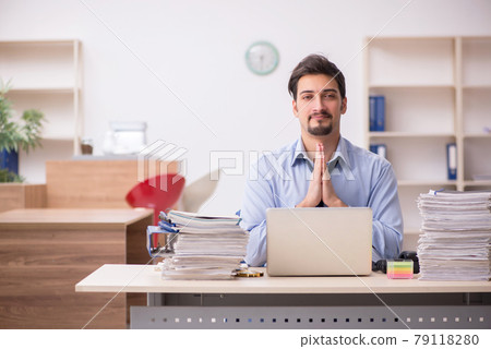 Young male employee and too much work in the office Young male employee and too much work in the office 79118280