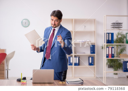 Young male employee sitting at workplace 79118368