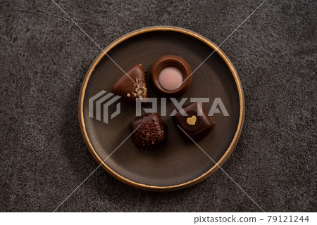 Bonbon chocolate on a plate 79121244