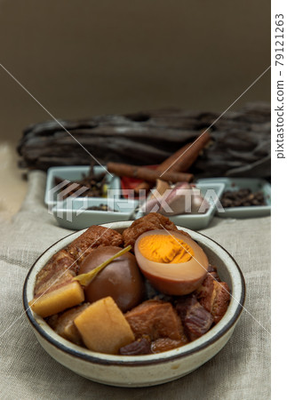 Boiled egg (kai pa lo) and Belly Pork Chinese Five-Spice Stewed with Tofu in brown sauce decorated with anise star, cinnamon, garlic and black pepper on old wooden table, Asia food. 79121263